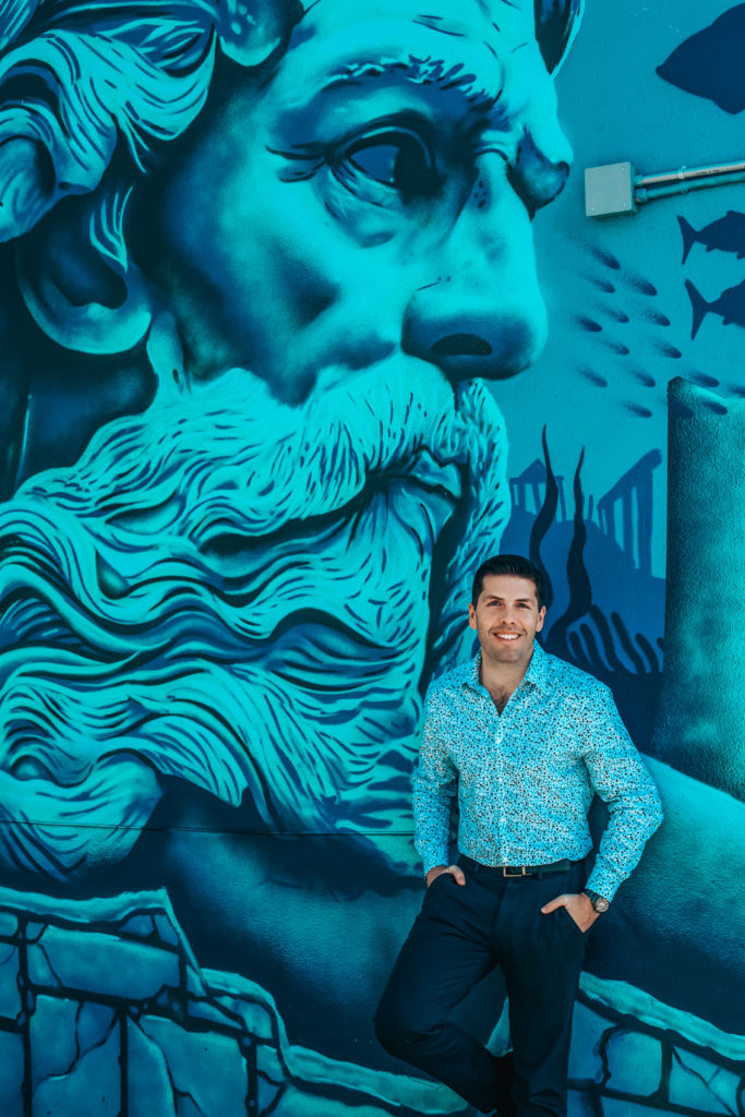 Stephen Trevathan photographed in front of Poseidon mural at Herman & Wells