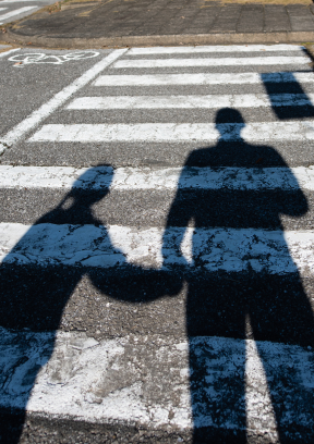 Shadows of a couple in the crosswalk highlight the risk of accidents at a Florida intersection.